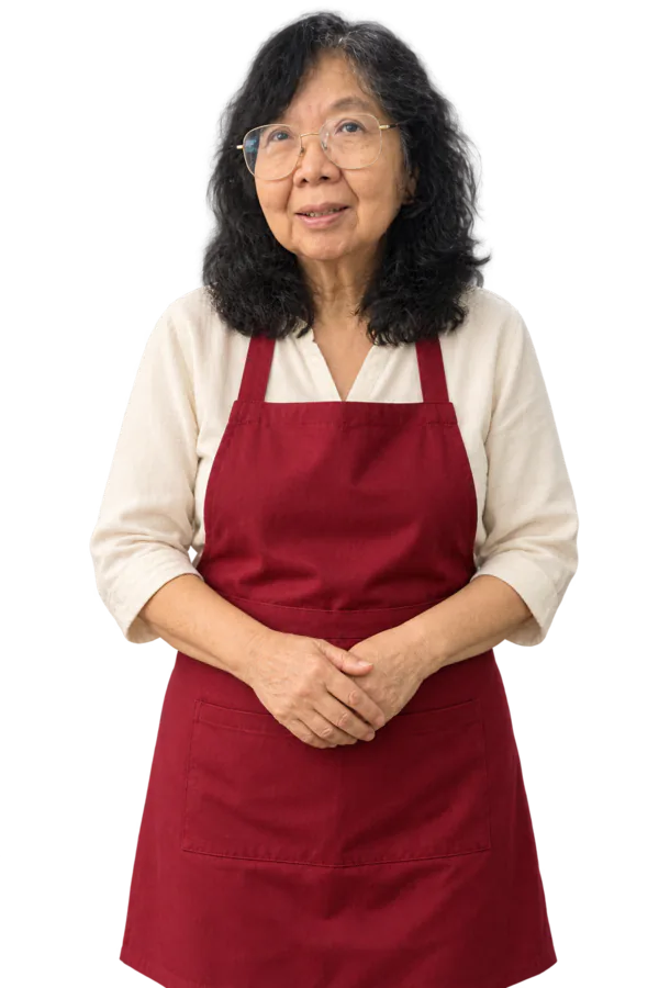 May Hwa, berkacamata dan bercelemek merah, tersenyum